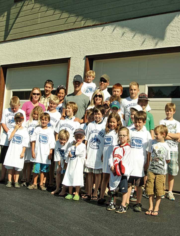 2011 — Columbia  Valley ice skaters pose with then Vancouver Canuck Mason Raymond in front of their new dry land training facility