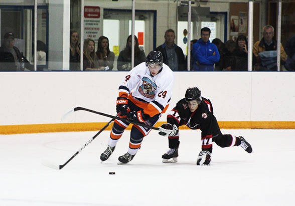 Rockies forward Bradley Palumbo does his best to get around the reach of a Kimberley player during the Rockies 4-3 overtime loss to Kimberley on Tuesday