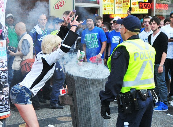 Hockey fans gather around a burning trash can in the early hours of the Stanley Cup riot in downtown Vancouver June 15.