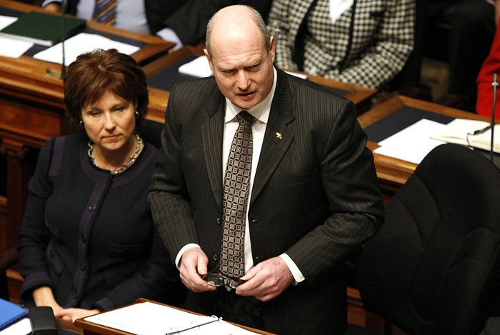 Premier Christy Clark listens as Finance Minister Mike de Jong presents the 2014-15 budget last February. The expected surplus has grown to more than $400 million since then.