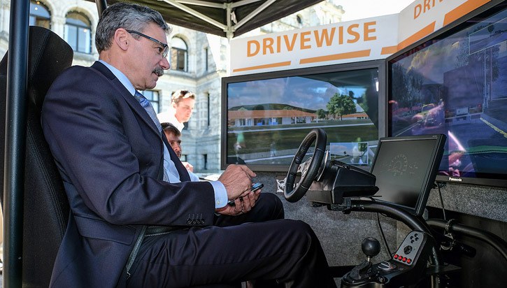 Public Safety Minister Mike Morris uses a driving simulator to show the effect of texting and driving.