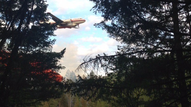 A bomber drops retardant on a fire off Tillicum Road in the BX-Swan Lake region on Tuesday evening (July 21