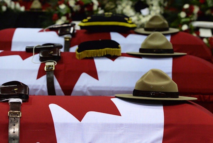The caskets for the three RCMP officers killed in last week's shootings in Moncton lay side-by-side at a funeral in New Brunswick on Tuesday.