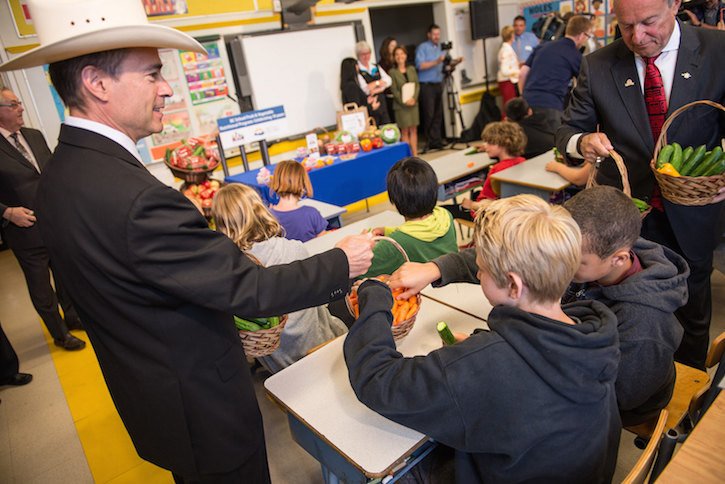 Agriculture Minister Norm Letnick (left) and Education Minister Peter Fassbender hand out fresh vegetables to children at a Victoria classroom this week