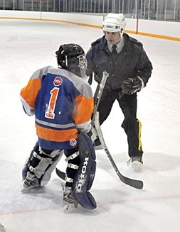 A coach you will listen to? A local RCMP member gives a lesson on goaltending to a minor hockey player in Invermere.