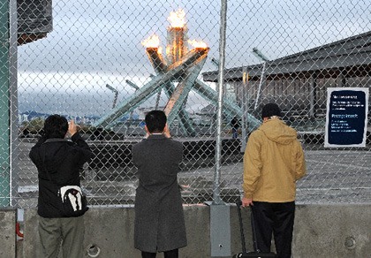 Olympic fans take pictures of the cauldron Tuesday morning