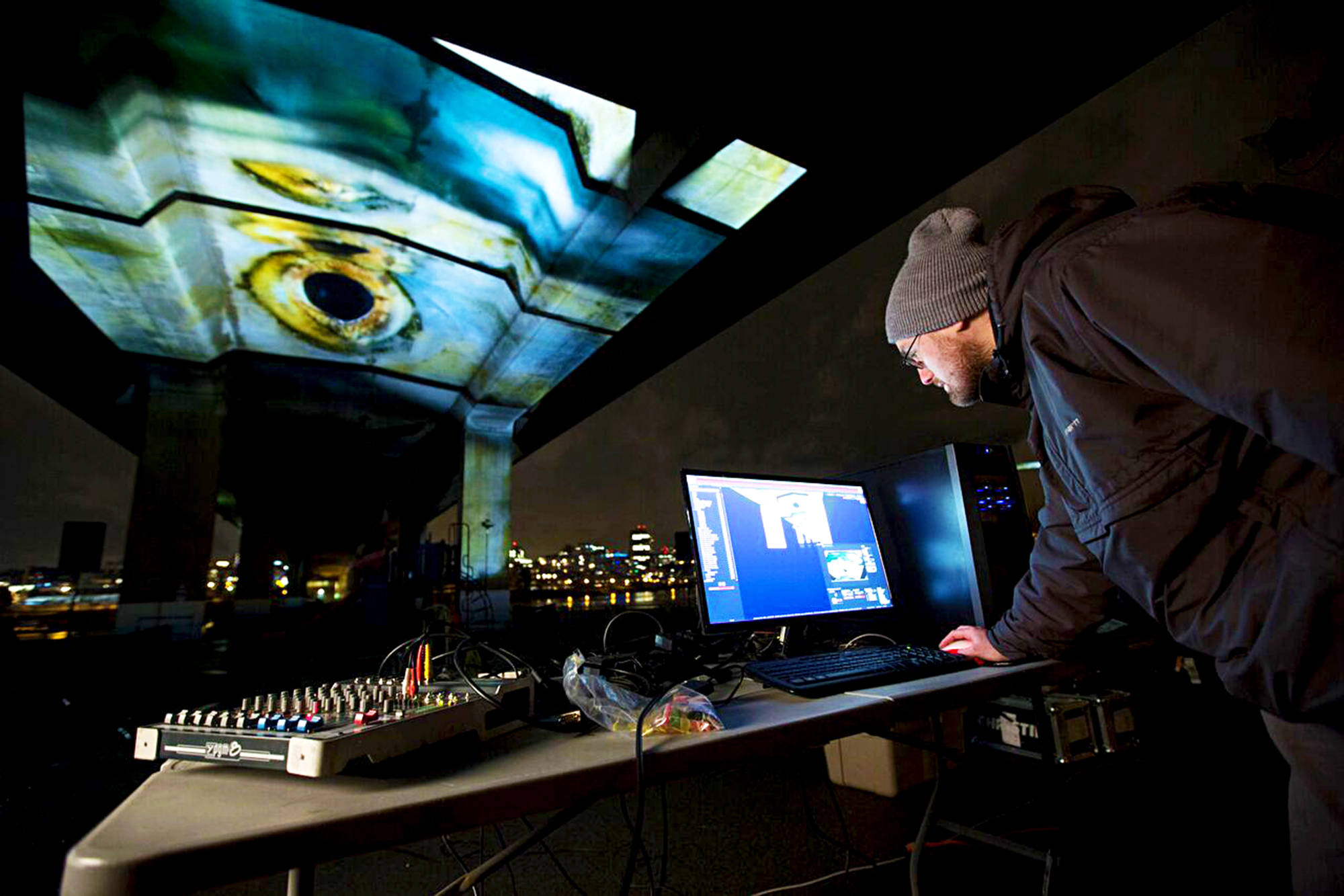 A technician works on the blend of cinematic storytelling and high-tech art installation under the Cambie Street Bridge in Vancouver.
