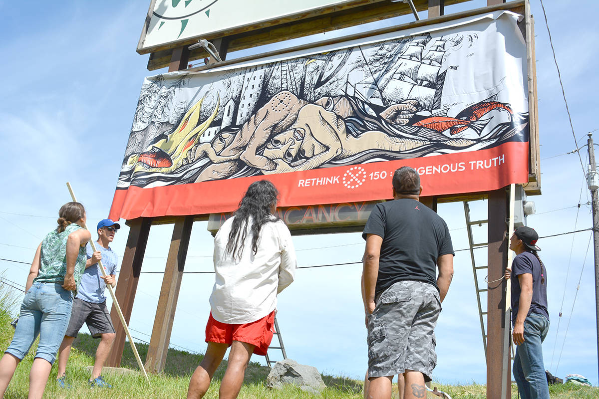 Volunteers set up a billboard created by the Rethink 150: Indigenous Truth Collective which aims to create a dialogue about Canada’s history, Saturday, June 17 at the north end of Duck Lake. - Credit: Carli Berry/Capital News                                Volunteers set up a billboard created by the Rethink 150: Indigenous Truth Collective which aims to create a dialogue about Canada’s history, Saturday, June 17 at the north end of Duck Lake. - Credit: Carli Berry/Capital News