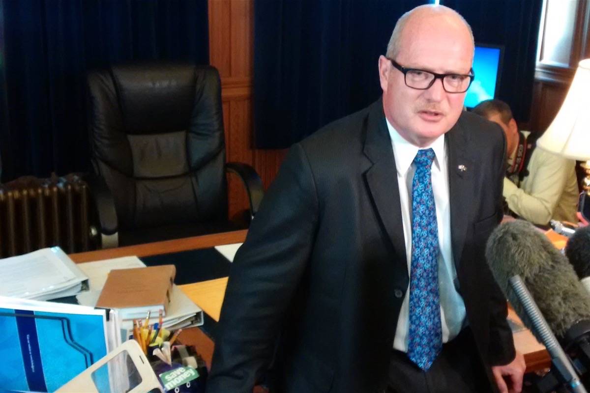 B.C. Liberal Finance Minister and house leader Mike de Jong speaks to reports at his legislature office Monday. (Tom Fletcher/Black Press)