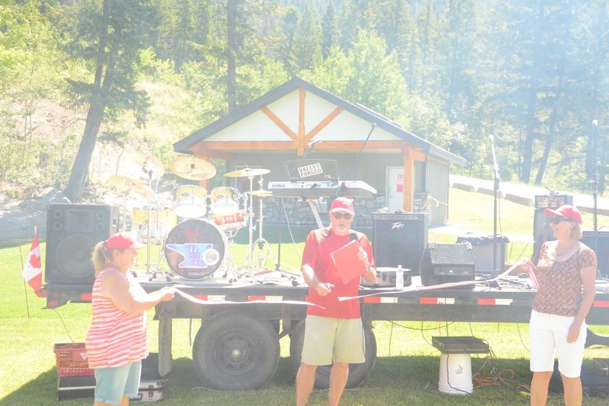 Amidst the smoke of tasty burgers and hot dogs cooking on the barbecue, Councillor Paul Marcil cuts the ribbon for the official opening of the updated Tilley Memorial Park in Canal Flats Friday, June 30th.Photo by Dean Midyette