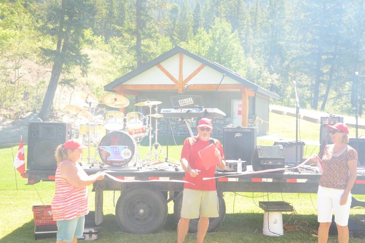 Amidst the smoke of tasty burgers and hot dogs cooking on the barbecue, Councillor Paul Marcil cuts the ribbon for the official opening of the updated Tilley Memorial Park in Canal Flats Friday, June 30th.Photo by Dean Midyette