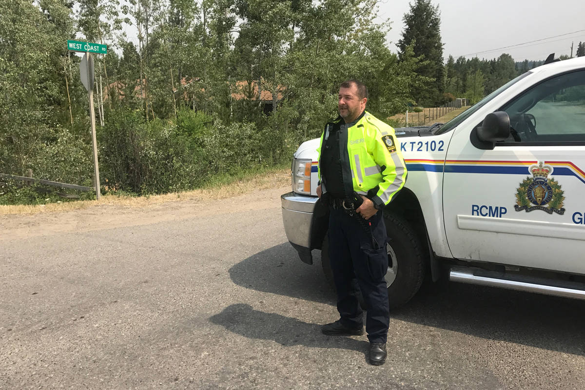 Sherrif Andy Abenthung secures an entrance to the Wildwood neighbourhood Sunday. The area remains under an evacuation order. Angie Mindus photo.