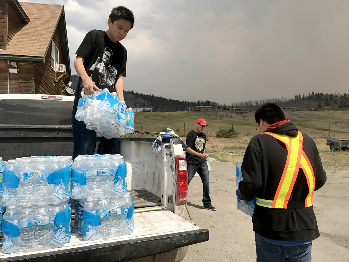 Preston Gilpin, 13, helps his community by unloading a water delivery.