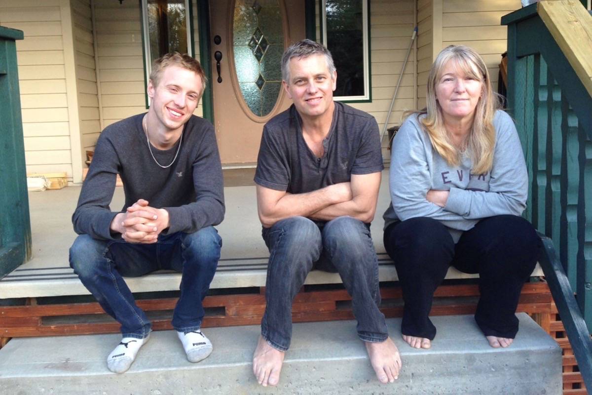 Cody, his dad Stan, and mother Darlene on the porch of their house which burned down in the Gustafsen fire.