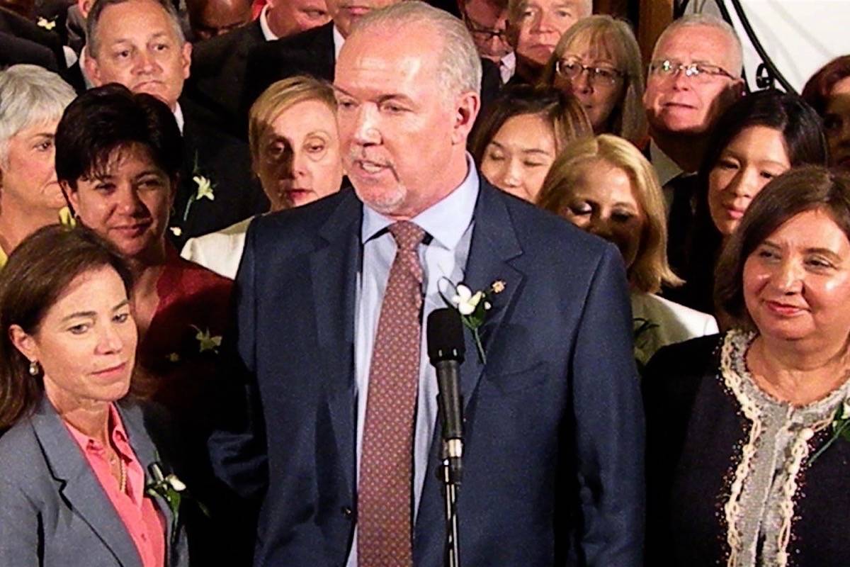 John Horgan is flanked by two prominent MLAs at swearing-in ceremony in May. Selina Robinson (left) is a likely pick for the new minister for mental health and addictions, and former B.C. Teachers’ Federation president Jinny Sims (right) is a contender for education minister. (Tom Fletcher/Black Press)