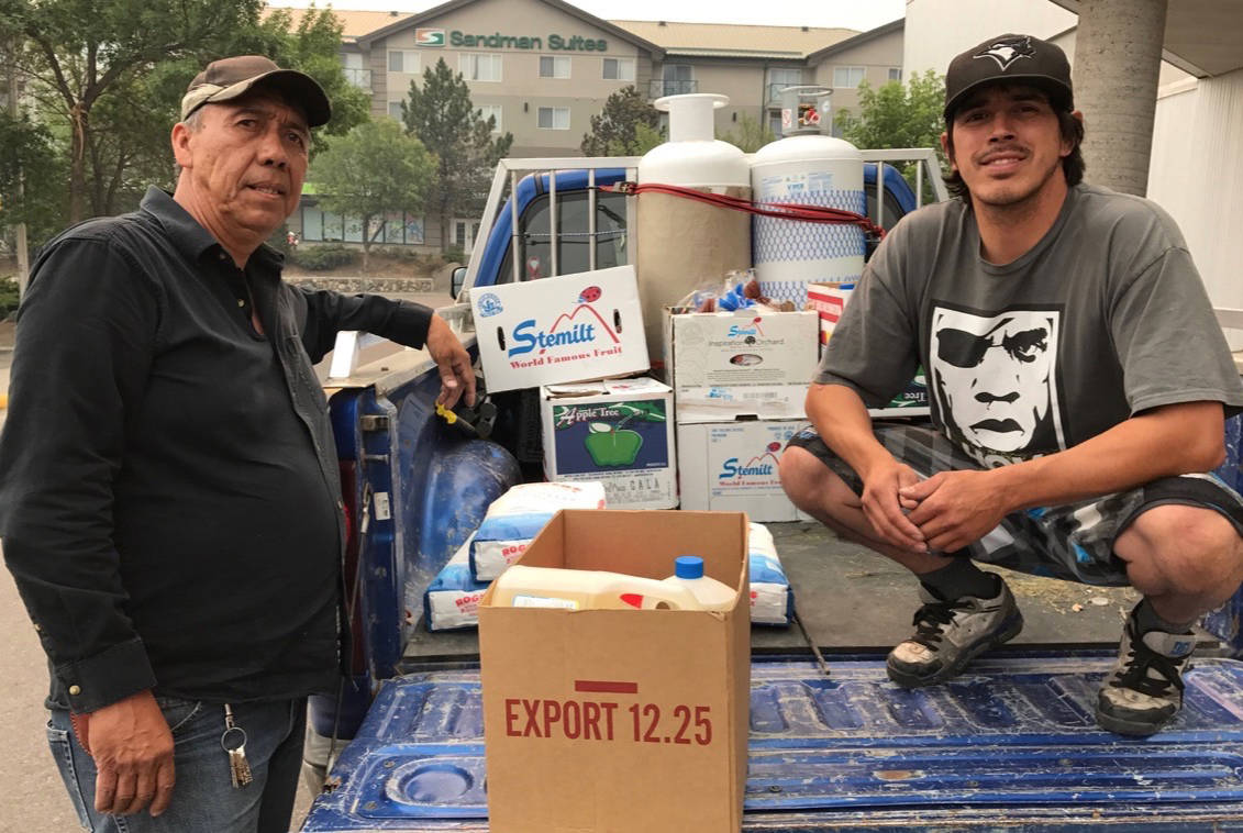 Anaham residents Cecil Grinder and Clayton Stump load up their vehicle with food and emergency supplies in Williams Lake Sunday evening with plans to take it back to community members in the evacuation zone in the Chilcotin.