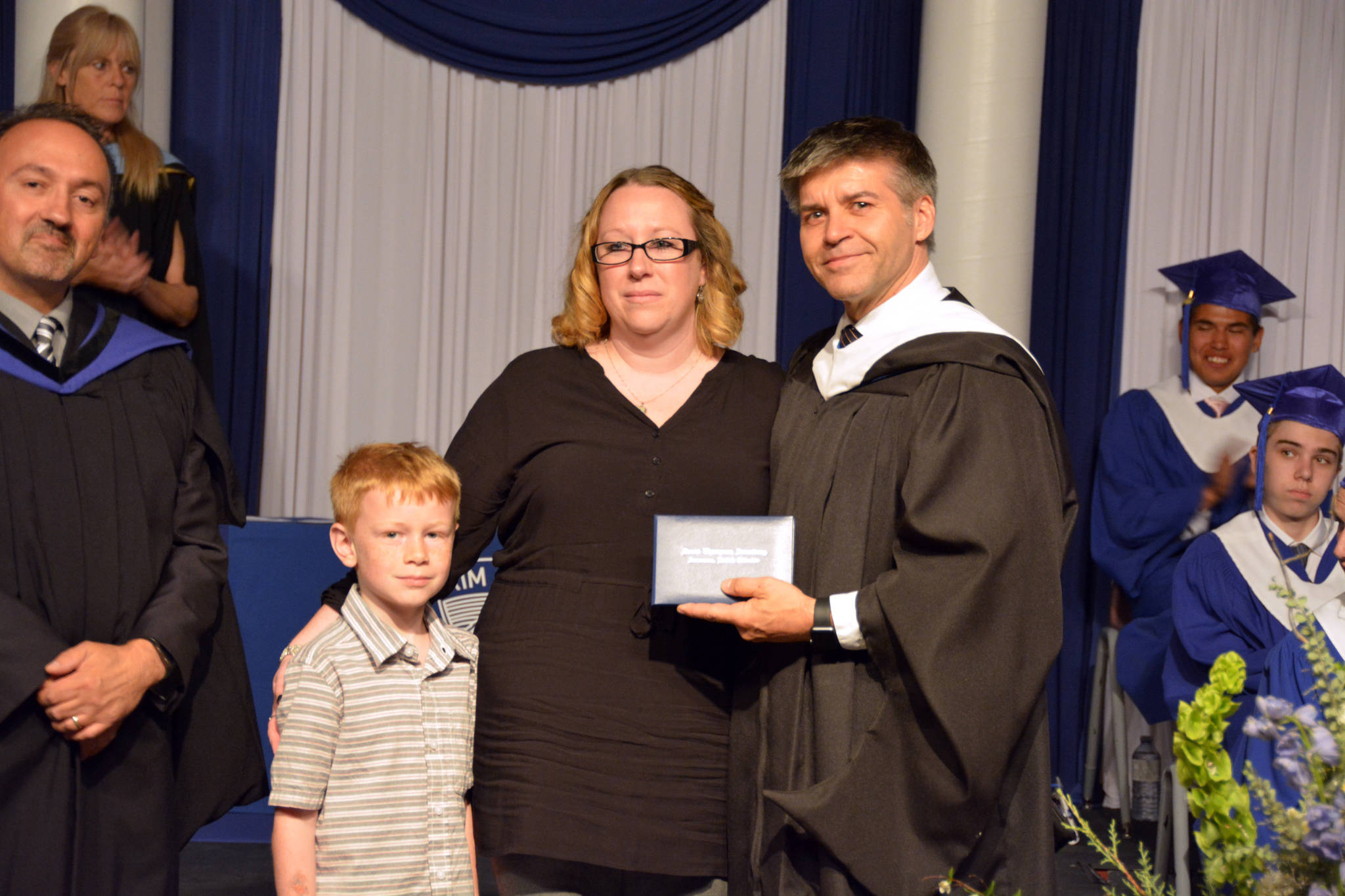 Photo by Lizzie Midyette                                In the end, Aislinn O’ Rourke decided to attend the DTSS commencement ceremony to accept her daughter’s diploma. Principal Darren Danyluk handed it to her, with Makayla’s younger brother Wyatt alongside.